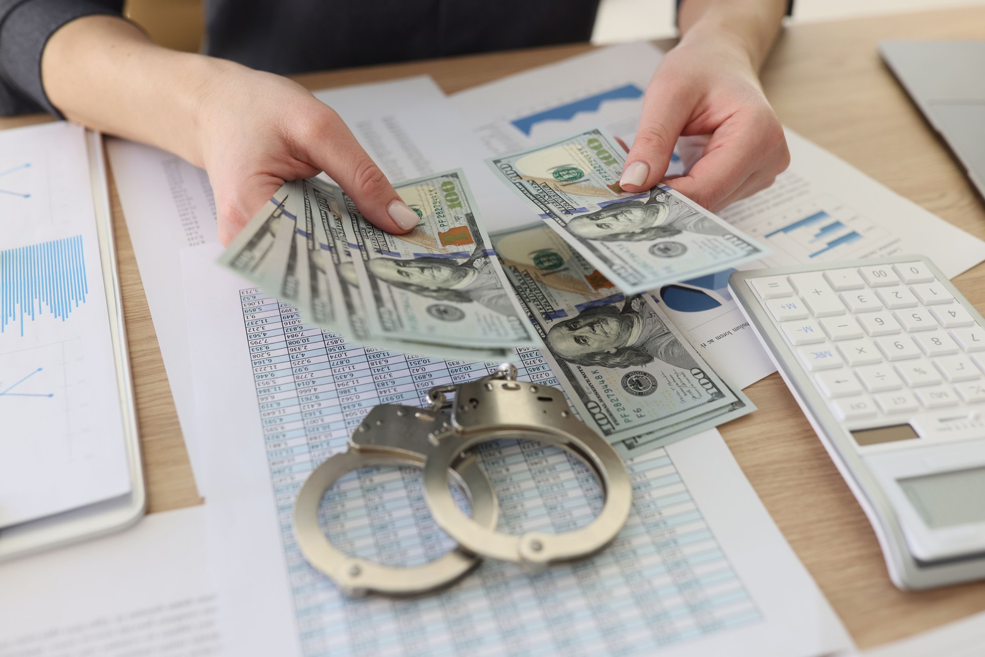 Accountant counts dollar banknotes sitting at office table